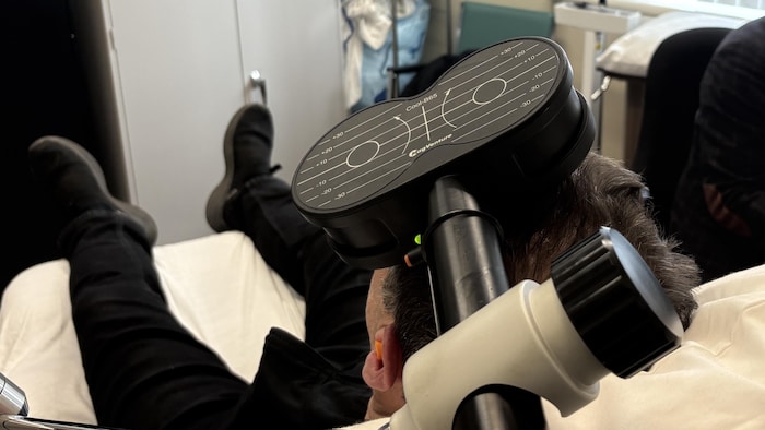 Un patient sur une chaise reçoit un traitement de stimulation magnétique.