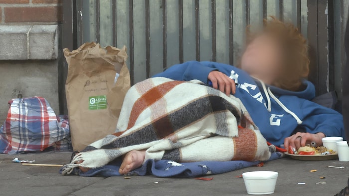 A Drug Addict Sleeps On A Sidewalk.