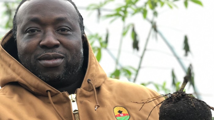 Toyin Kayo-Ajayi à l'entrée d'une serre agricole. 