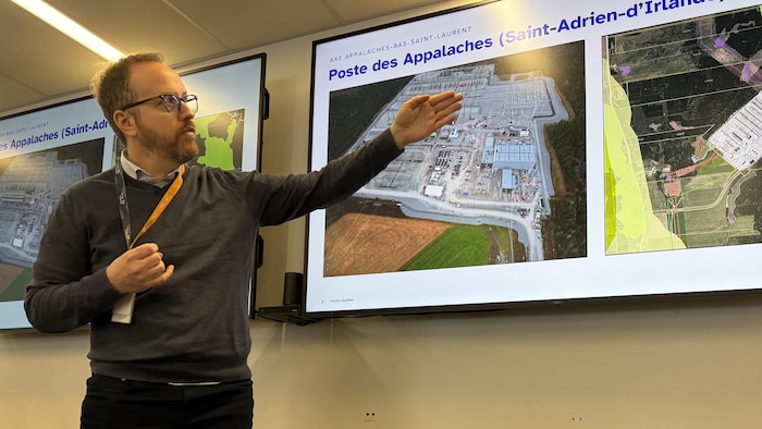 Un homme se tient debout devant une image représentant le poste des Appalaches.