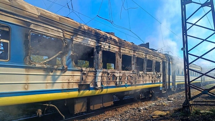 De la fumée s'élève d'un train de voyageurs à la suite d'une frappe de drone russe dans la région de Kharkiv, en Ukraine, le 9 septembre 2026.