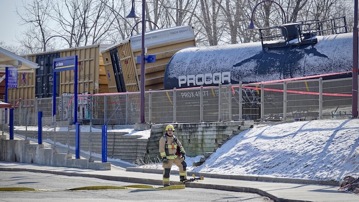 Un pompier devant deux wagons déraillés.