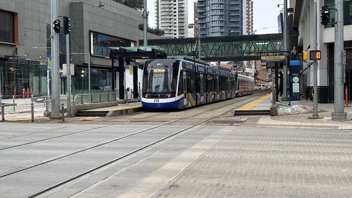 Un train circule dans une ville en milieu urbain.