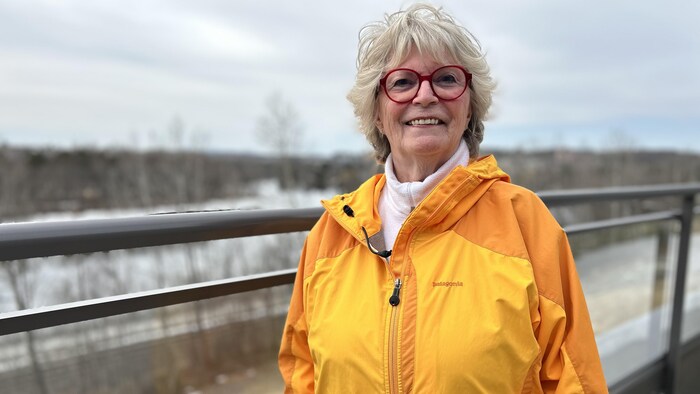 Une femme sourit à la caméra.