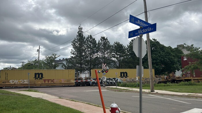 Un train et des panneaux avec des noms de rues.