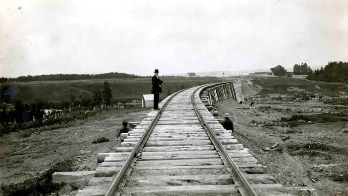 Un homme attend la Punaise sur un rail.