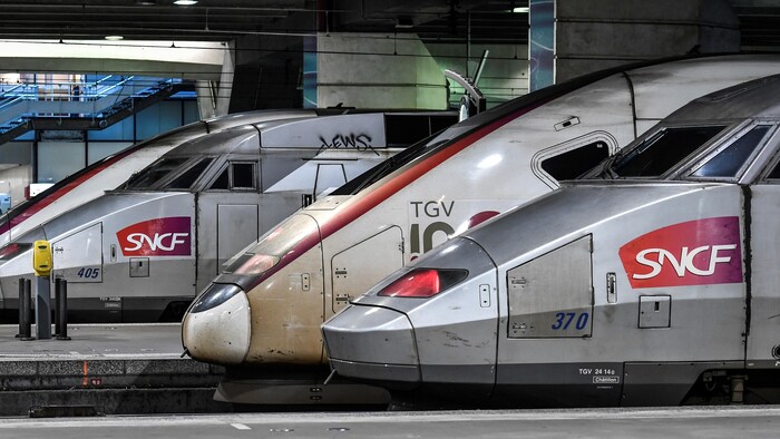 Des locomotives estampillées SNCF à l'arrêt, dans une gare.