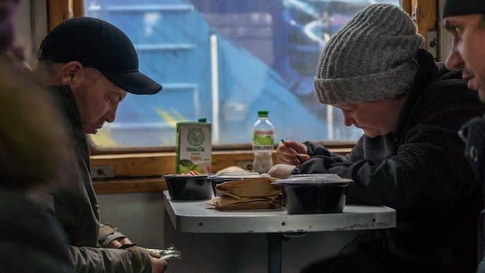 Des Ukrainiens se réchauffent dans un train pendant l'hiver. 