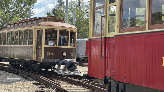 Deux wagons de tramway sont immobiles sur des rails.