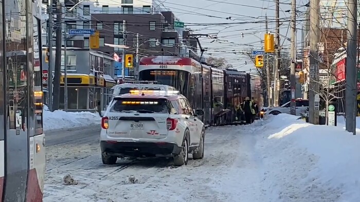 Un véhicule d'urgence de la CTT derrière le tramway qui a déraillé sur la rue Queen à Toronto, le 26 janvier 2026.