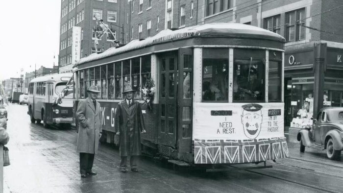 Le maire de Regina, Garnet Menzies, à droite, en compagnie d'un surintendant municipal devant un tramway de la ville en 1950.