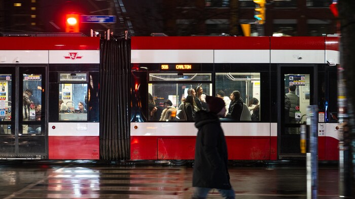 Des personnes portant des bandeaux festifs dans un tramway à Toronto, le mardi 31 décembre 2024, à l'occasion du Nouvel An.