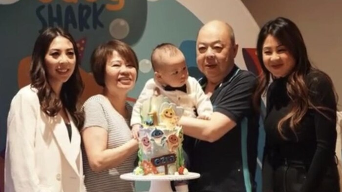庄志雄怀生前抱小外孙与太太以及两个女儿合影，右边为Chiristina Trang。