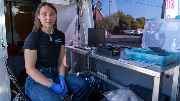 Nicole Fieduna est assise à une table où se trouvent les outils servant à analyser les drogues.