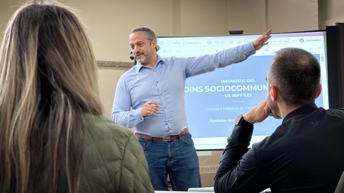 Un homme pose des questions à un groupe de citoyens. 