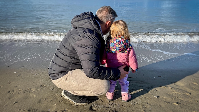 Un père et sa fille regardent la mer, à Vancouver.