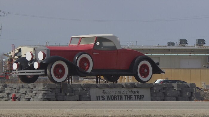 Une statue représentant une voiture, souhaitant la bienvenue dans la ville de Steinbach.
