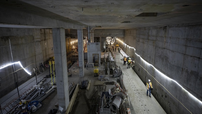 Des travailleurs sur le chantier de construction souterrain du SkyTrain à Vancouver, sous la rue Broadway, le 2 juin 2025.