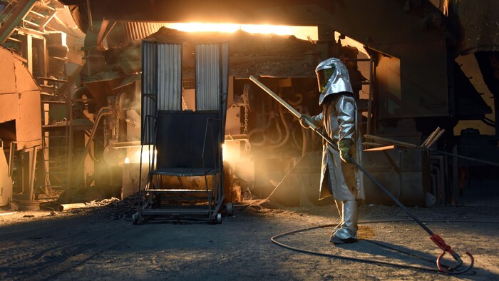 Un travailleur travaille à proximité d'un fourneau.