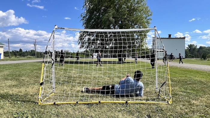 Des travailleurs étrangers temporaires jouent une partie de soccer sur un terrain vague de la Ferme Chaumont.