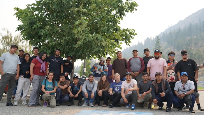 Une photo de groupe, devant un arbre.