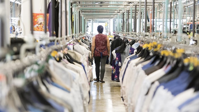 عاملة تسير داخل مصنع للألبسة في مونتريال.