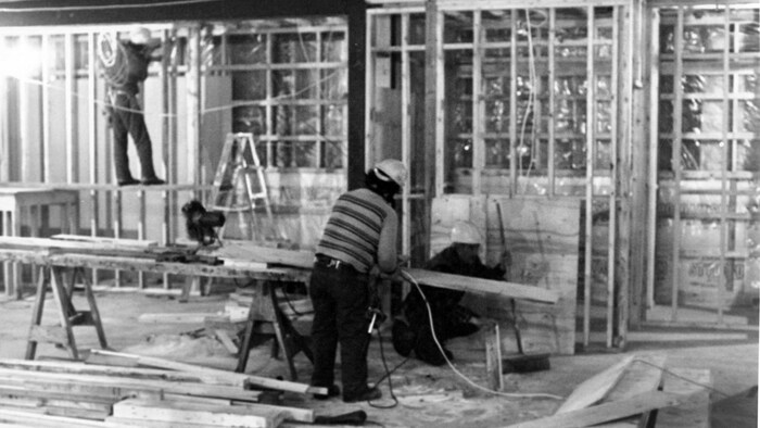 Photo d'archives en noir et blanc. Deux hommes font des travaux de menuiserie.