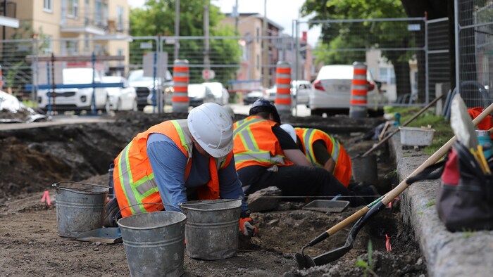 Des travailleurs effectuent des travaux archéologiques dans une rue.