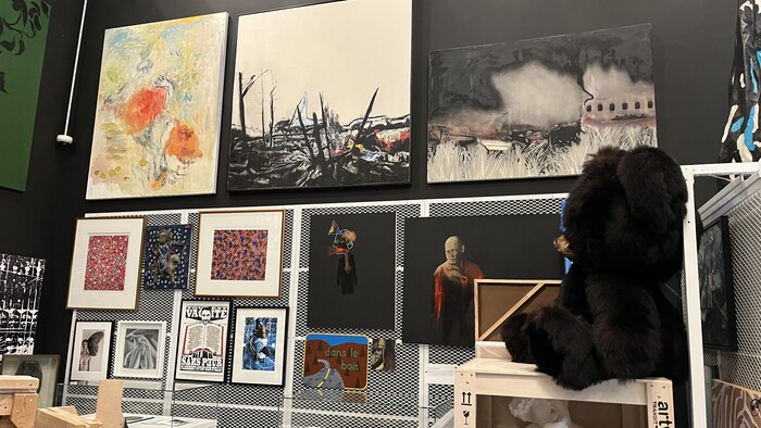 Des peintures et des sculptures placées dans une salle d'exposition.