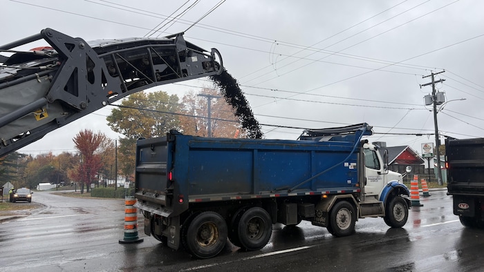 Un camion verse une matière dans un camion.