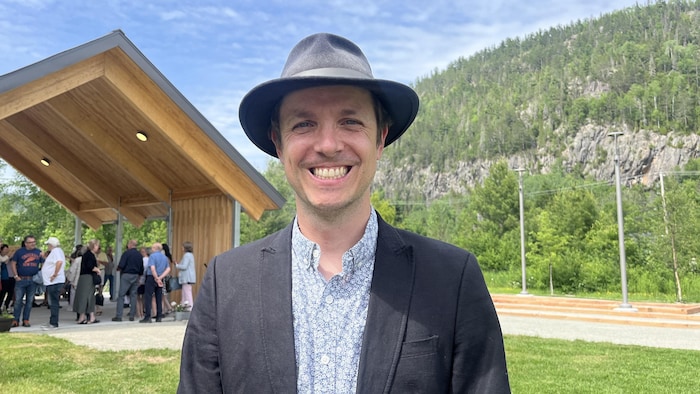 Philôme Lafrance devant un pavillon en bois dans un parc.