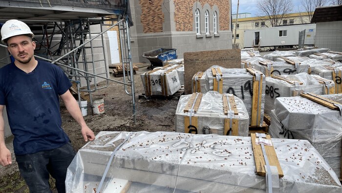 Une personne avec un casque dans un chantier de construction près d'une cathédrale.