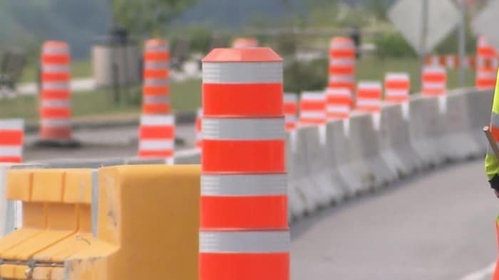 Un chantier de construction avec un cône orange en avant-plan.