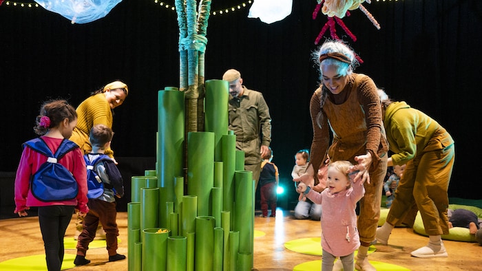 Des enfants autour de l’arbre, symbole de la production « Tree » participant au spectacle interactif sur la scène.