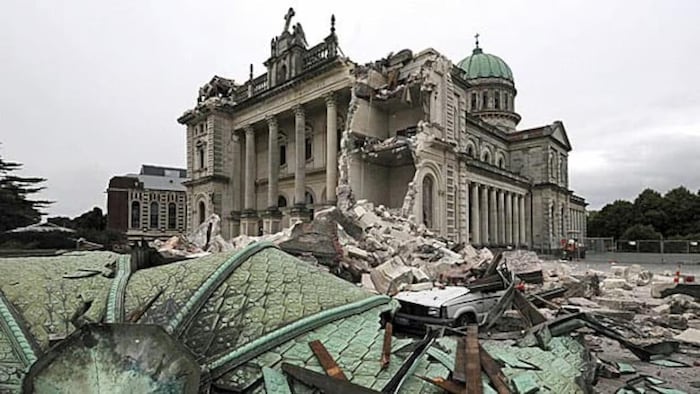Une cathédrale démolie. Sous le bâtiment, une voiture a été ensevelie et écrasée par les décombres.