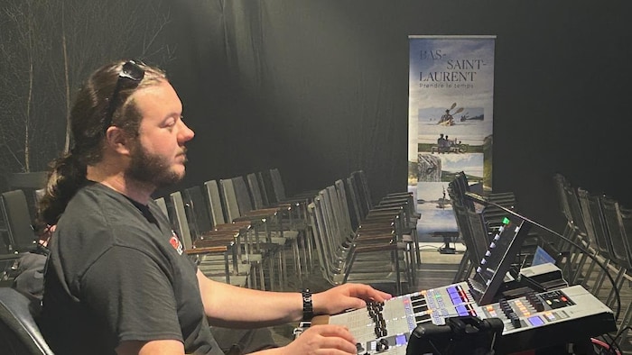 Un homme devant une console. 