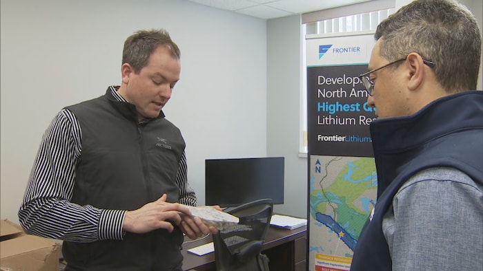 Le PDG de Frontier Lithium, Trevor Walker, tient un échantillon qui contient du lithium. Il est accompagné de Bora Ugurgel, responsable des communications et des relations avec les investisseurs.