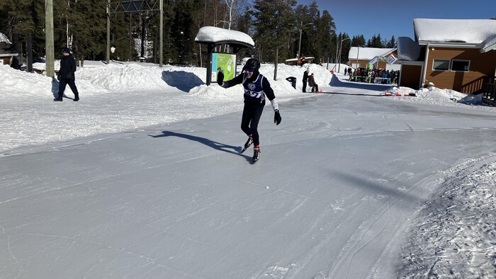 Un homme salue quelqu'un de la main en patinant.