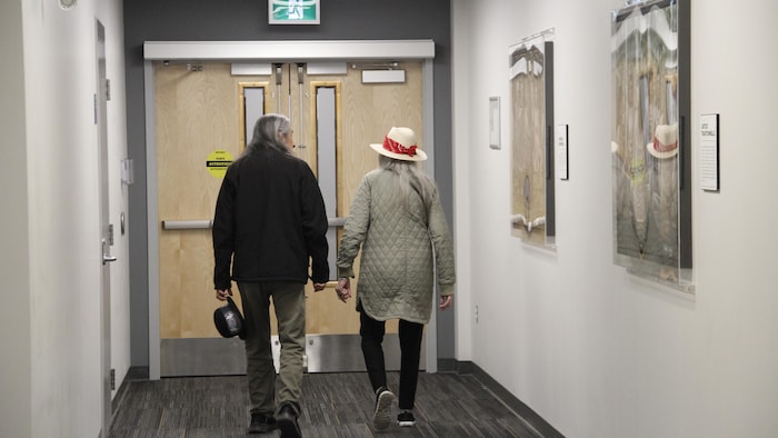 Deux personnes marchent de dos dans le tribunal.