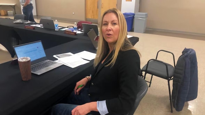 Trina Jones assise à table dans une salle de réunion.
