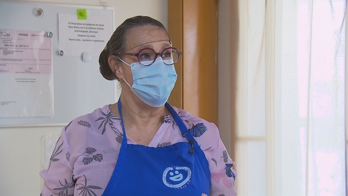 Une femme avec un masque prend la pose.