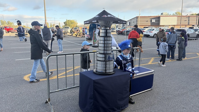 Un enfant est pris en photo à côté du trophée Gilles-Courteau.