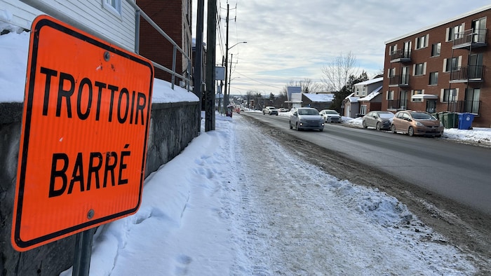 Un trottoir avec une indication trottoir barré. 