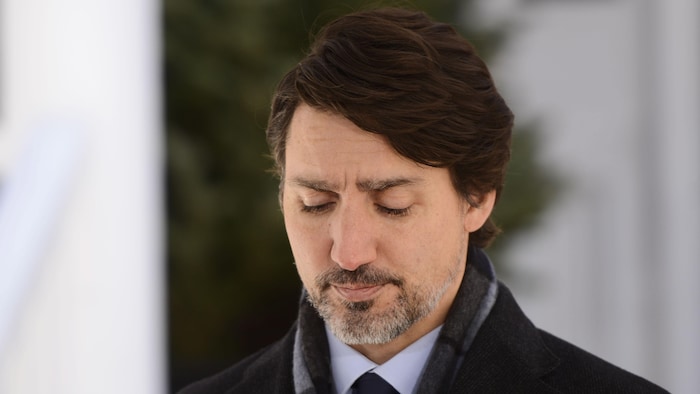 Gros plan de Justin Trudeau, le regard vers le sol, devant sa résidence d'Ottawa.