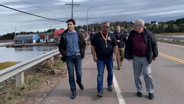 Justin Trudeau marche sur un pont en compagnie d'autres personnes.
