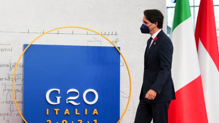 جوستان ترودو يمشي في قمة العشرين في روما مرتدياً قناع وجه يقي من الفيروسات. 