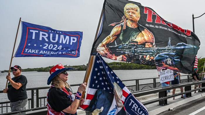 Des partisans de Donald Trump brandissant des drapeaux portant son nom ou le présentant comme un combattant armé.