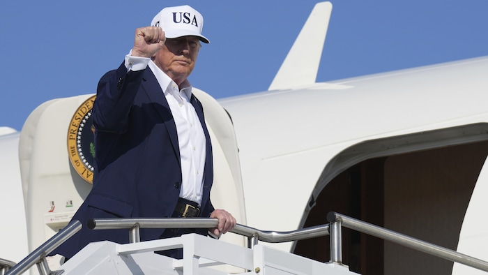 Donald Trump fait un geste de la main avant de monter à bord de l'avion présidentiel Air Force One.