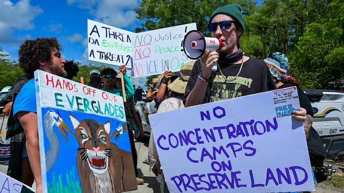 Un militant tient une pancarte sur laquelle on lit : "pas de camp de concentration sur des aires protégées".