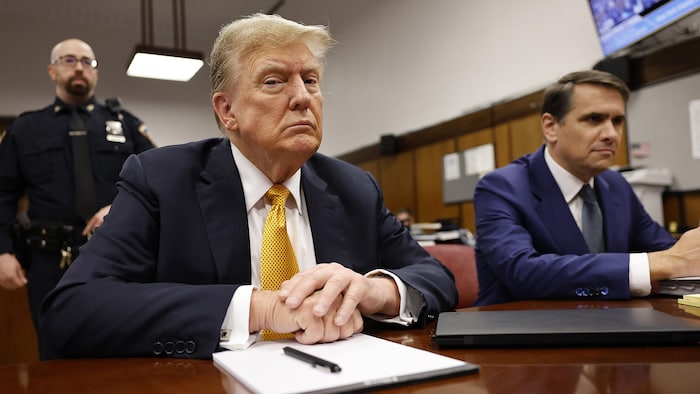 Donald Trump est assis dans la salle d'audience du tribunal pénal de Manhattan aux côtés de son avocat Todd Blanche.